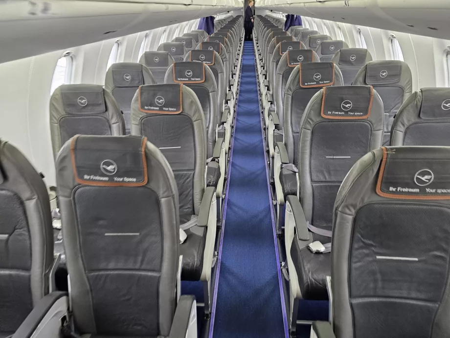 Cabină la clasa business, cabină la clasa economică în fundal