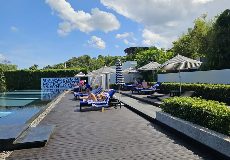 Șezlonguri lângă piscina comună